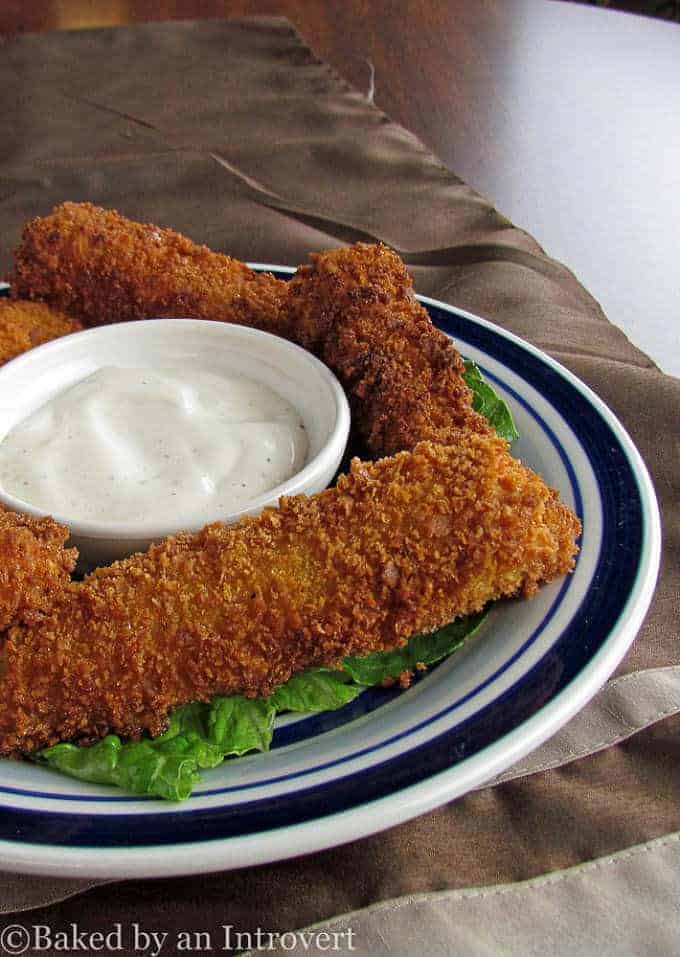 Fried Pickle Spears  on a plate with a ramekin of ranch dressing.