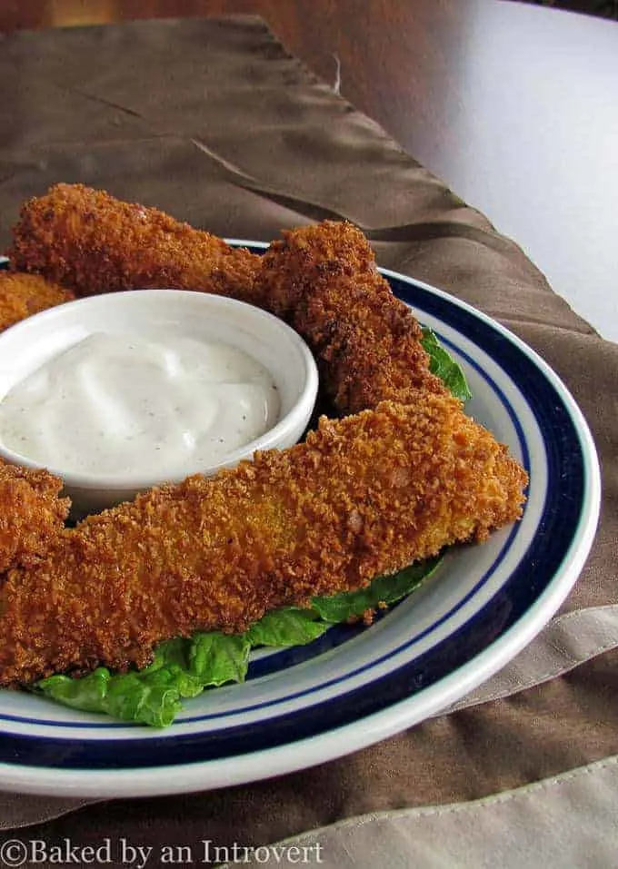 Fried Pickle Spears on a plate with a ramekin of ranch dressing.