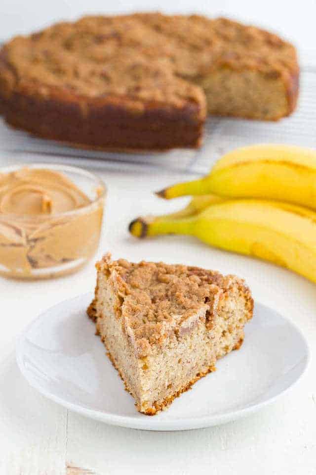 side view of a slice of peanut butter and banana coffee cake on a white plate
