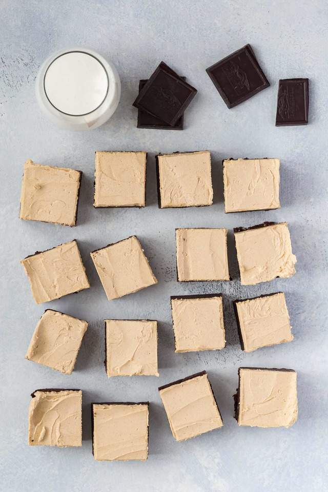 overhead view of fudgy brownies with peanut butter frosting and a glass of milk