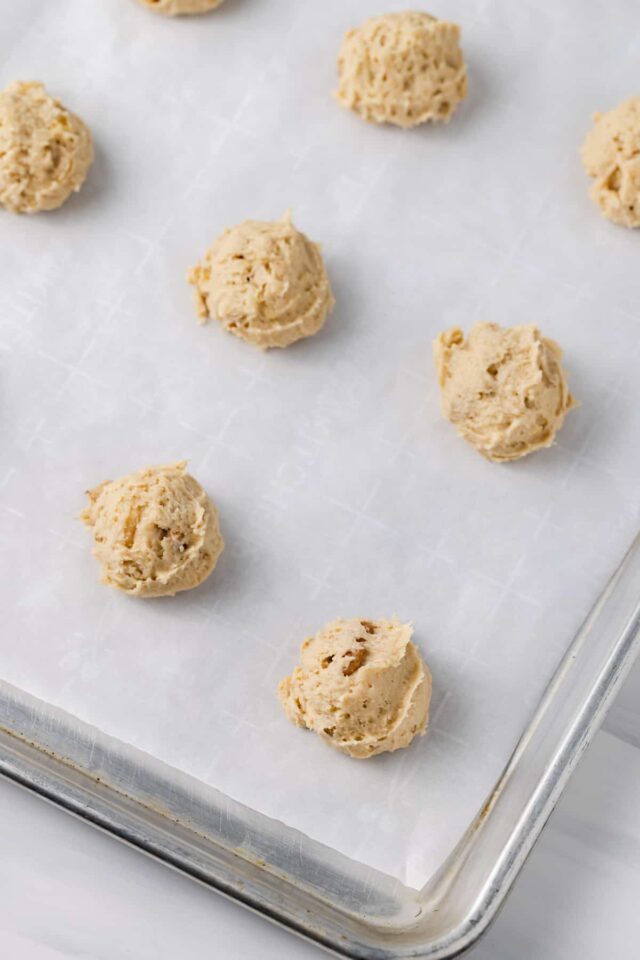 Scoops of banana bread cookie dough on a baking sheet