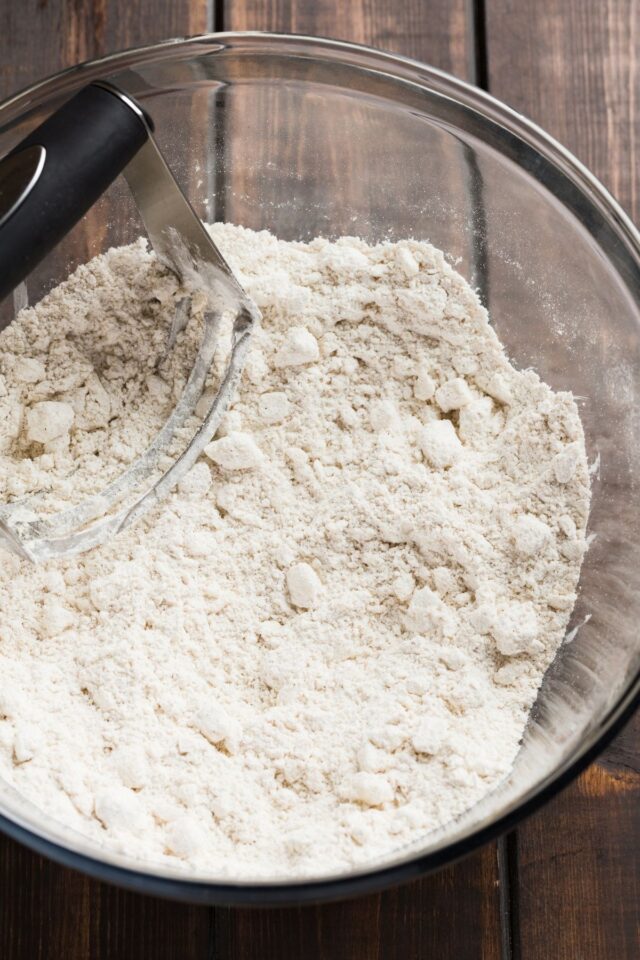 Butter cut into flour in a glass mixing bowl.