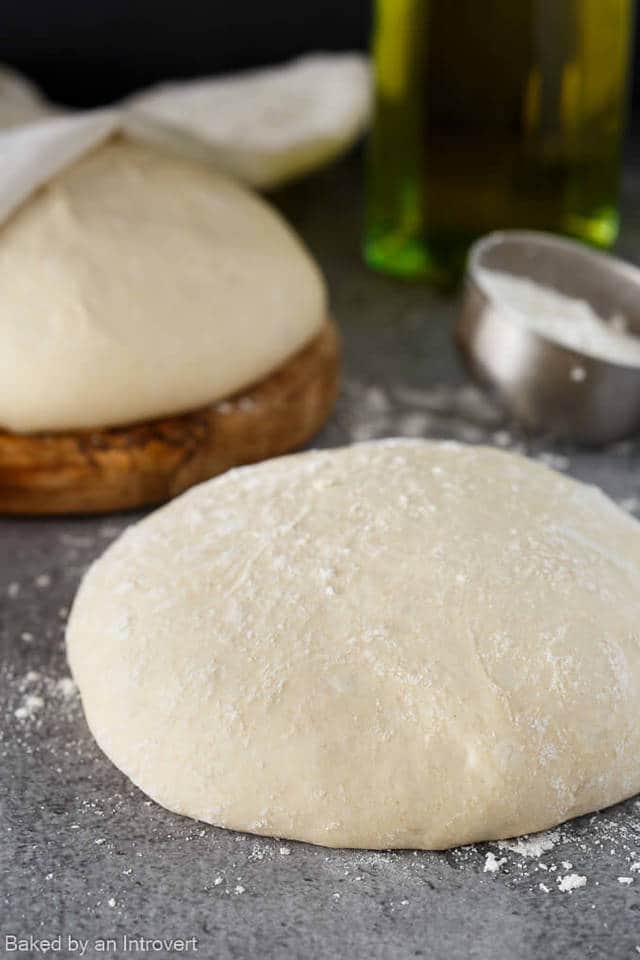 side view of pizza dough on a gray background