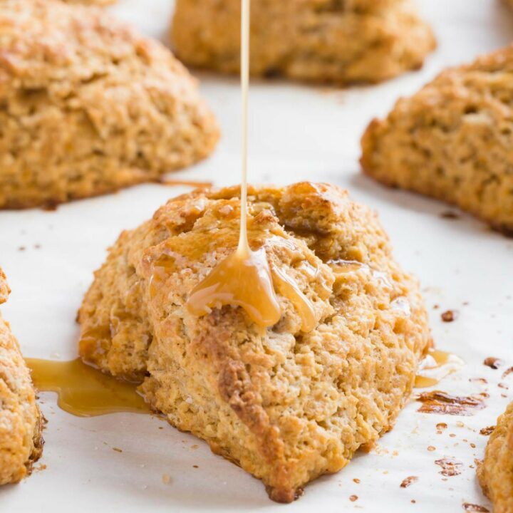 Honey citrus glaze being drizzled over baked sweet potato scones.