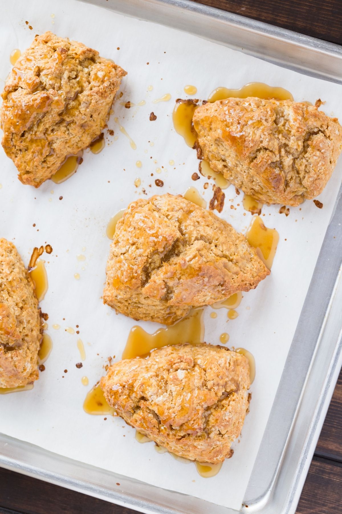 Baked Honey Citrus Sweet Potato Scones on a baking sheet lined with white parchment paper.