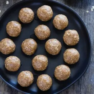 No Bake Almond Butter Balls neatly arranged on a black plate