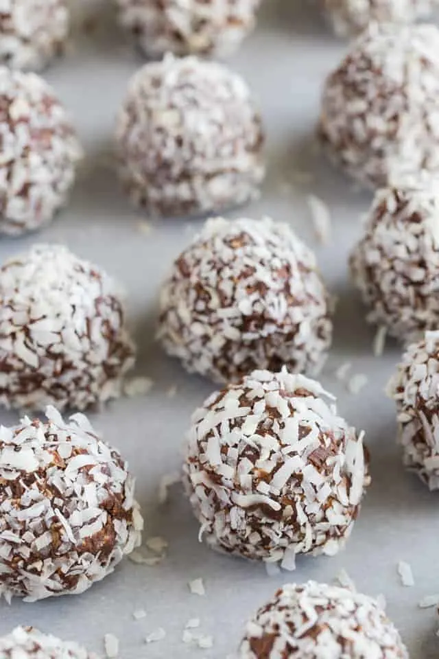 Chocolate Peanut Butter Oatmeal Balls with Coconut Chocolate peanut butter oatmeal balls with coconut lined neatly on a baking sheet covered in white parchment paper.