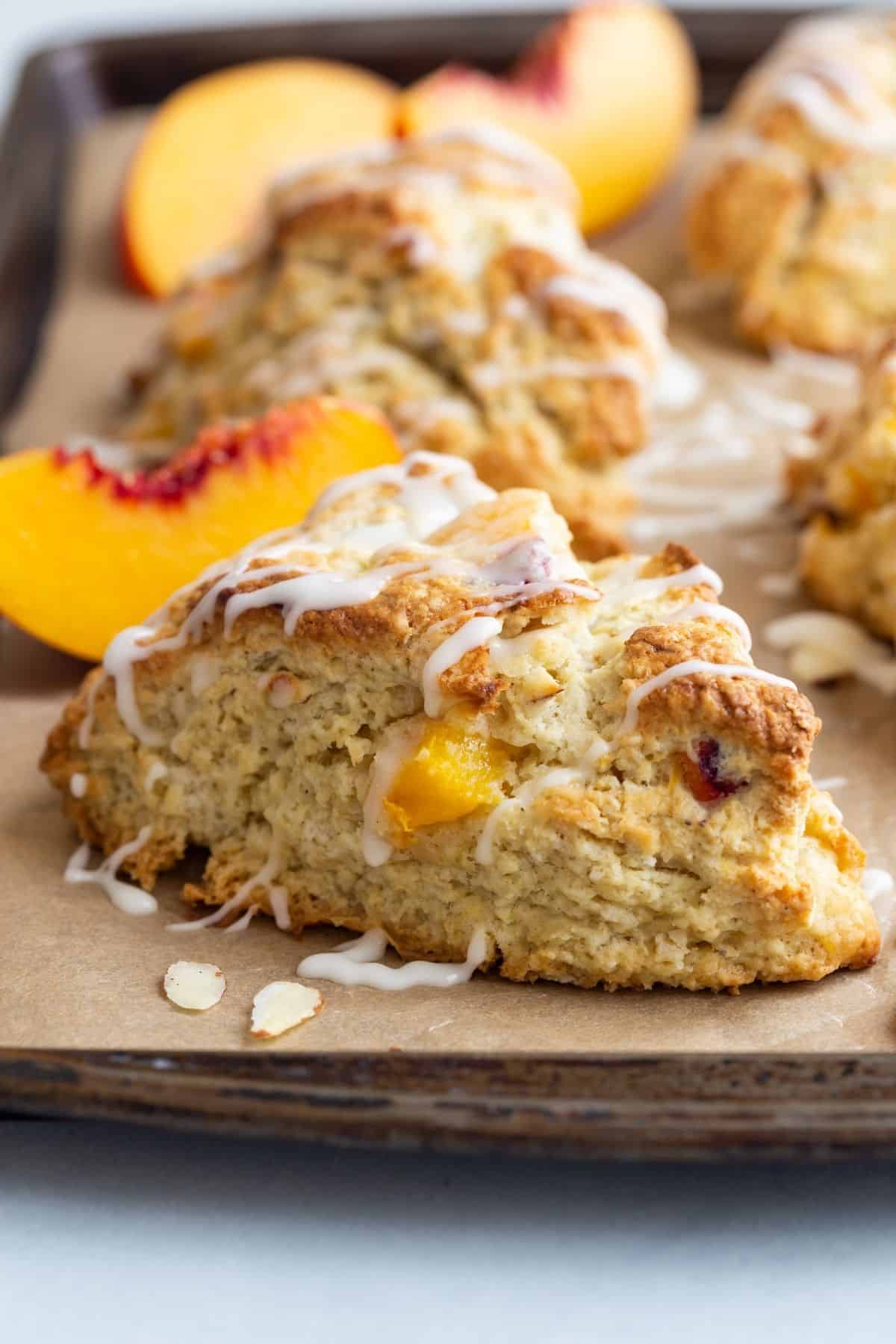 Side view of peach scones on a baking sheet.