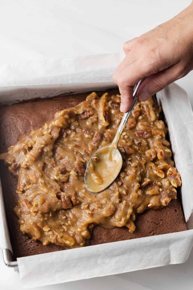 A spoon spreading pecan pie brownies topping