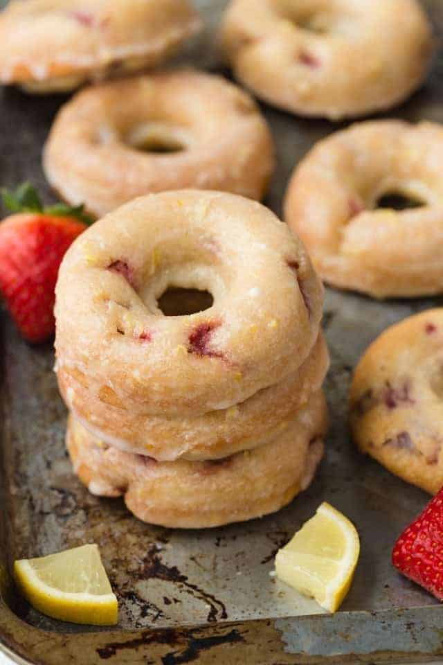 Strawberry Donuts with Lemon Glaze stacked on a baking sheet