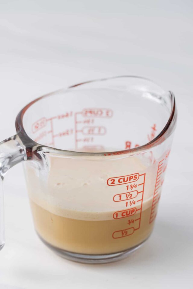 Apple cider and yeast in a measuring cup
