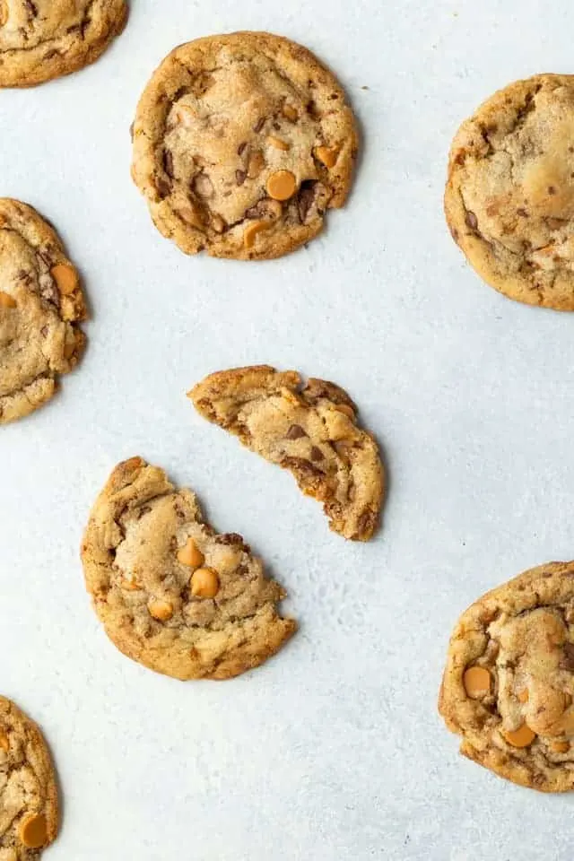 butterscotch toffee cookie broken in half on a white background