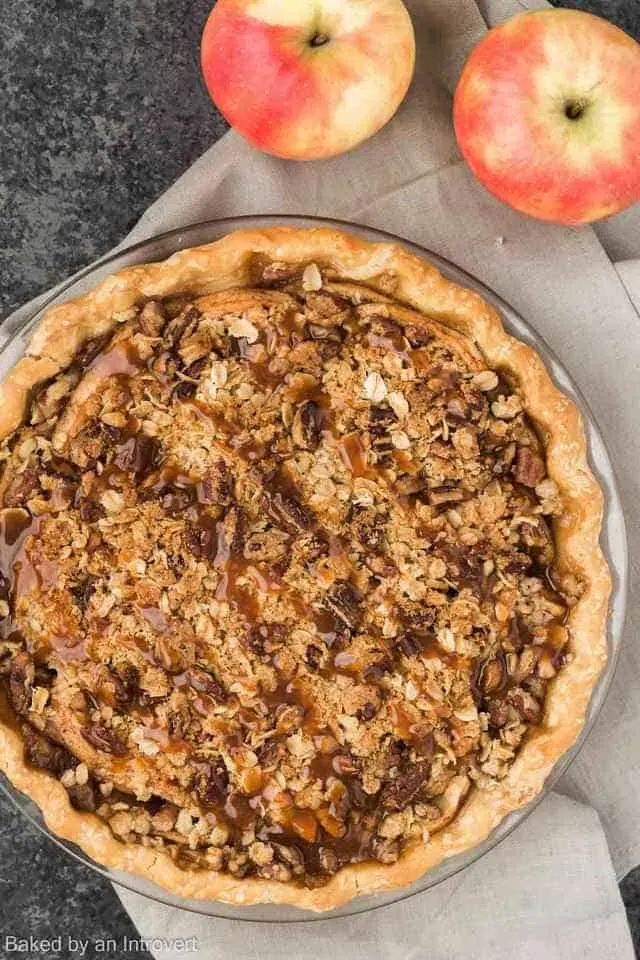 Overhead view of a caramel apple pecan streusel pie in a glass dish.