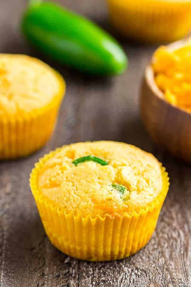 Angled view of cheddar jalapeño cornbread muffins in yellow paper liners.