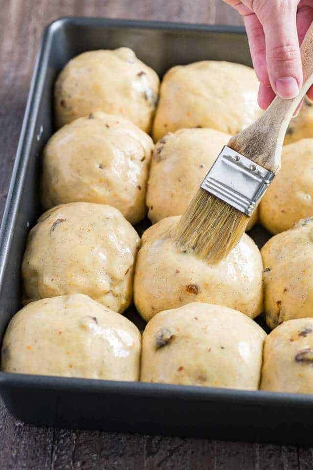 hot cross bun being brushed with butter