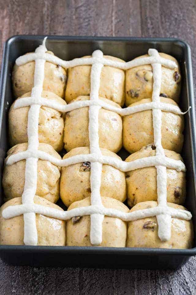 unbaked hot cross buns in a pan