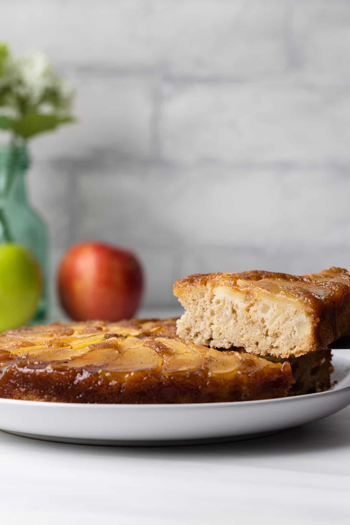 Apple upside down cake with a slice being served