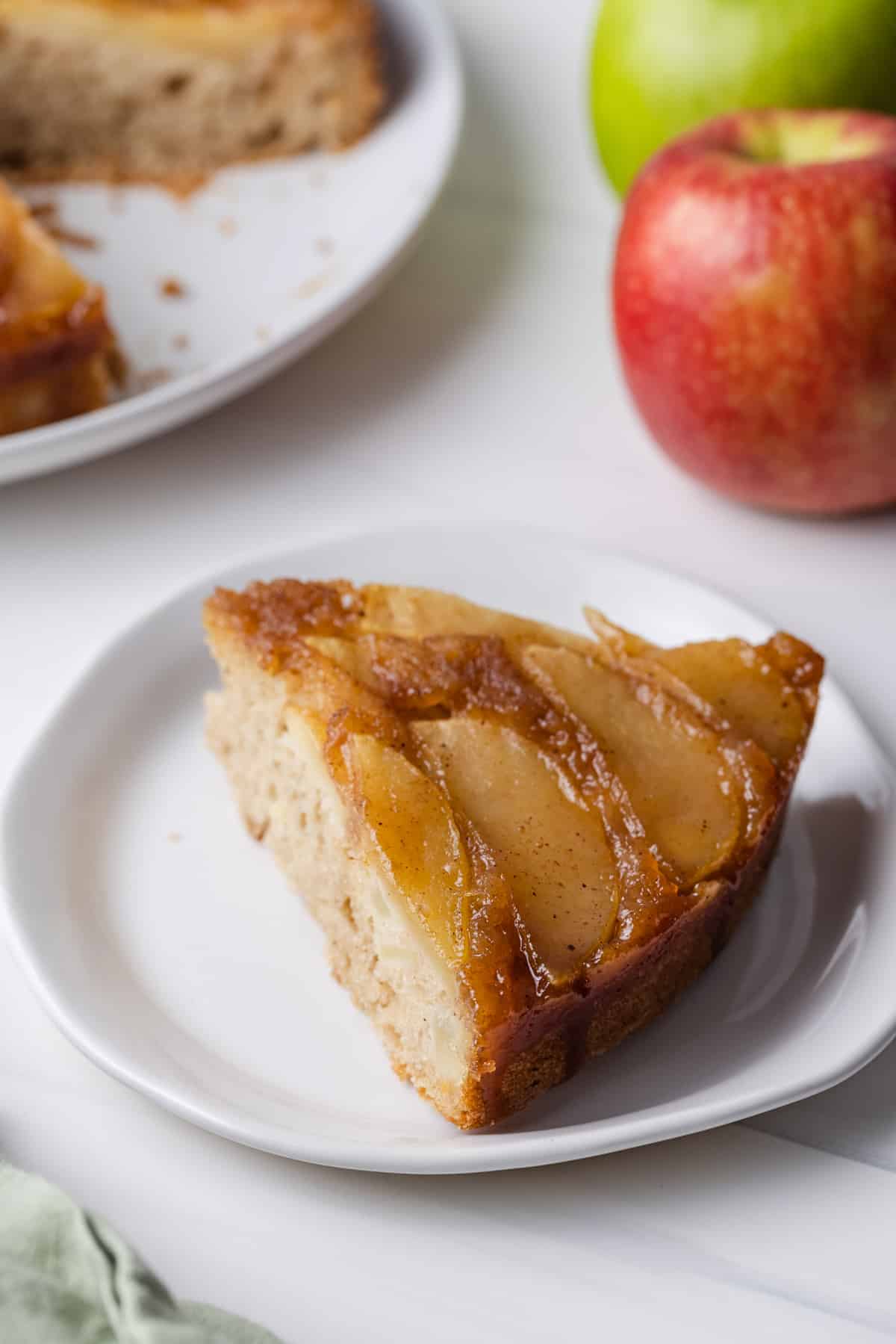 A slice of apple upside down cake on a plate