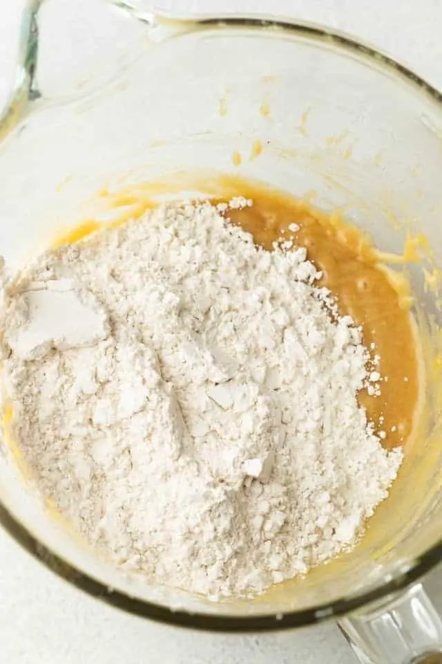 wet and dry ingredients for cookie dough in a glass bowl