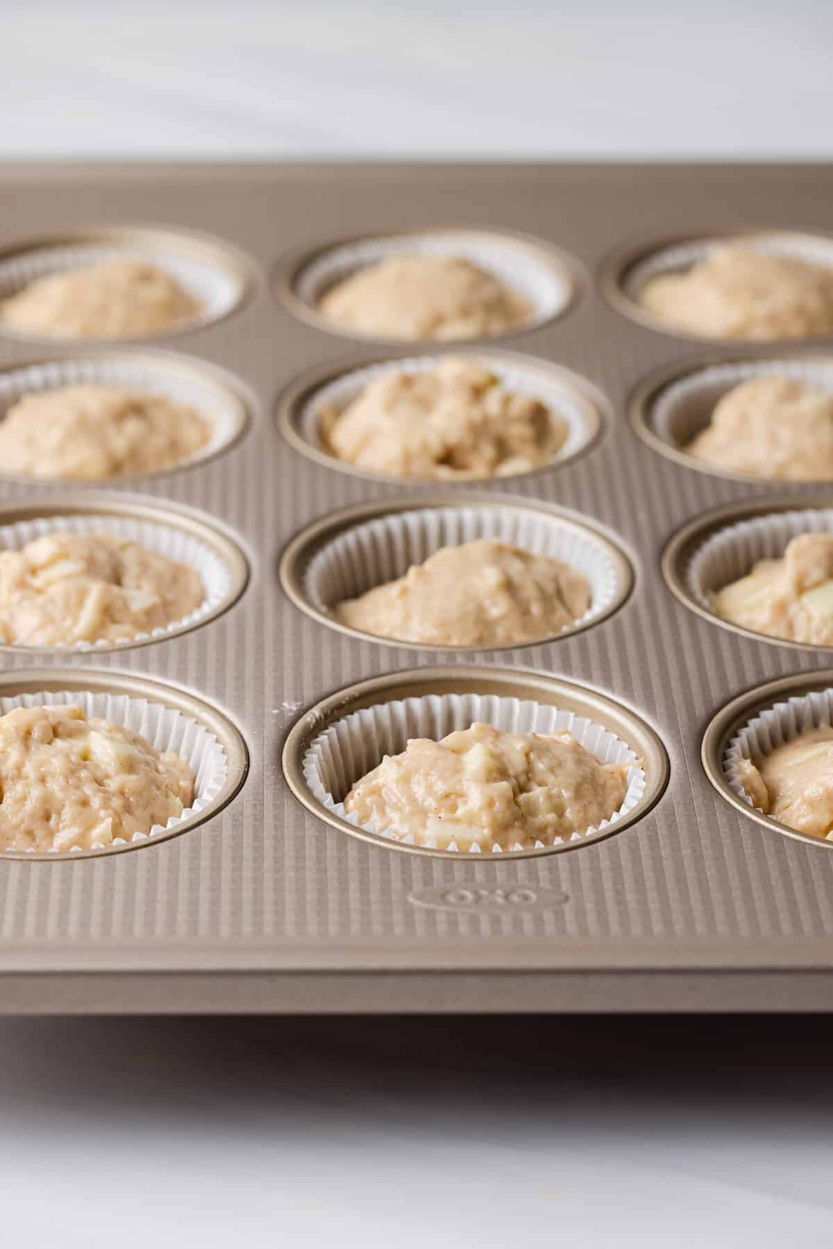 Apple muffin batter in muffin tins