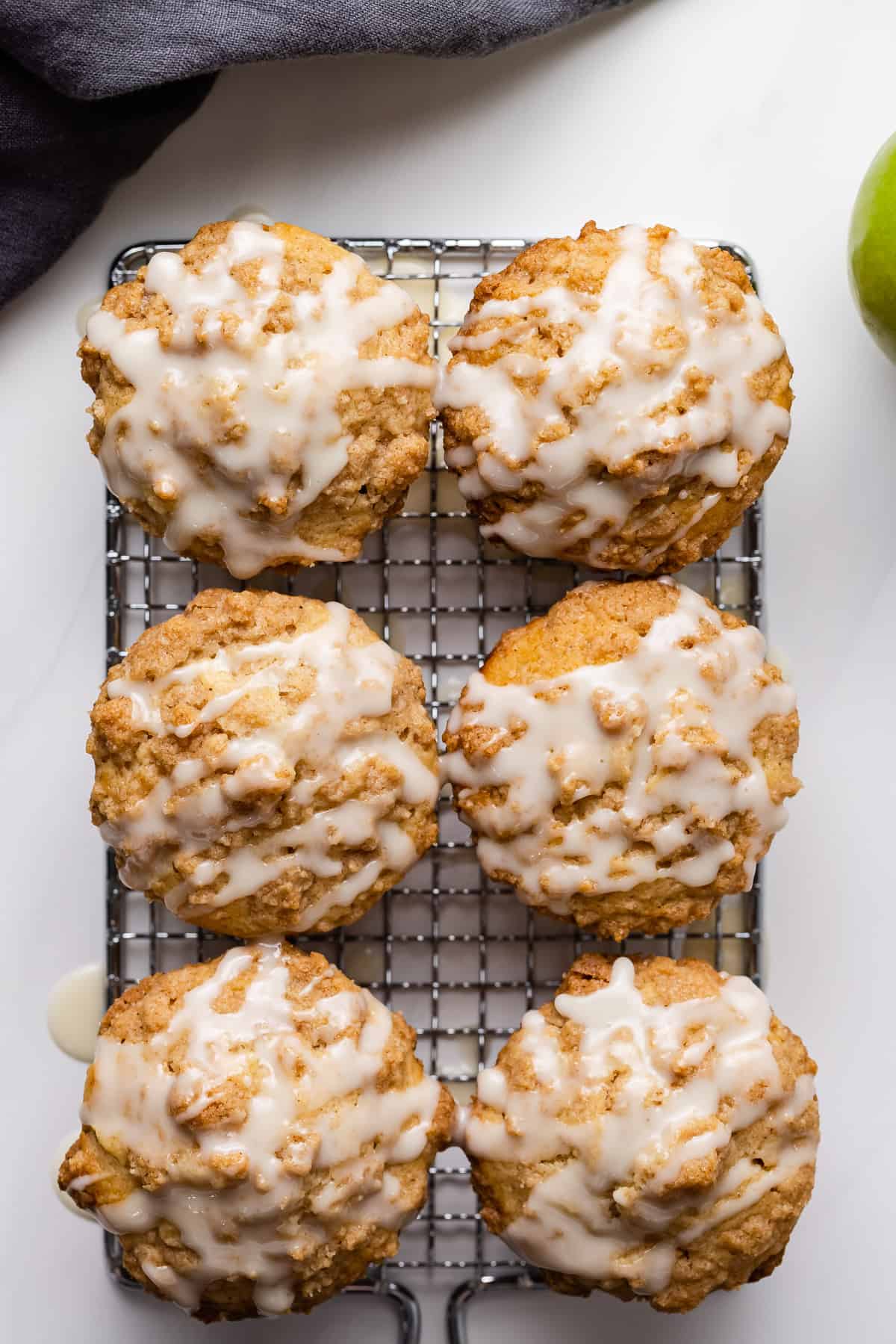 Apple streusel muffins topped with glaze on a wire rack