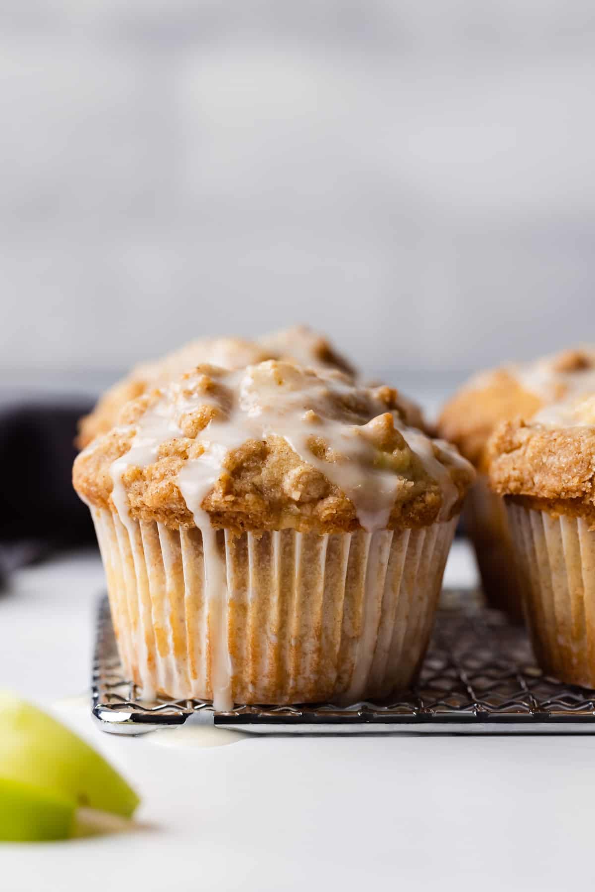 Two apple streusel muffins topped with glaze