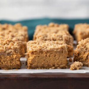 pumpkin bars on brown board with parchment paper