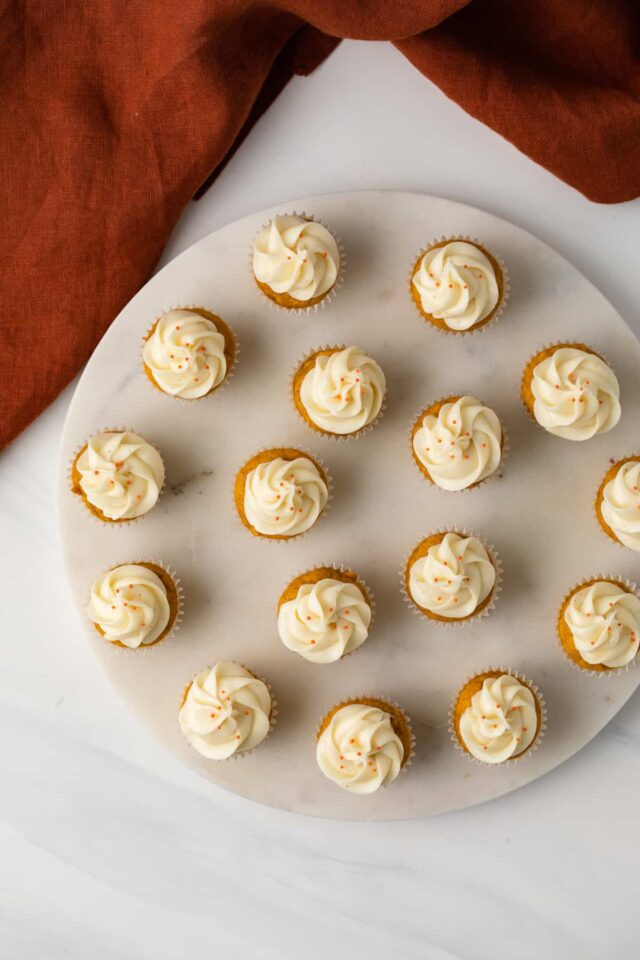 Overhead view of mini pumpkin ginger cupcakes with frosting