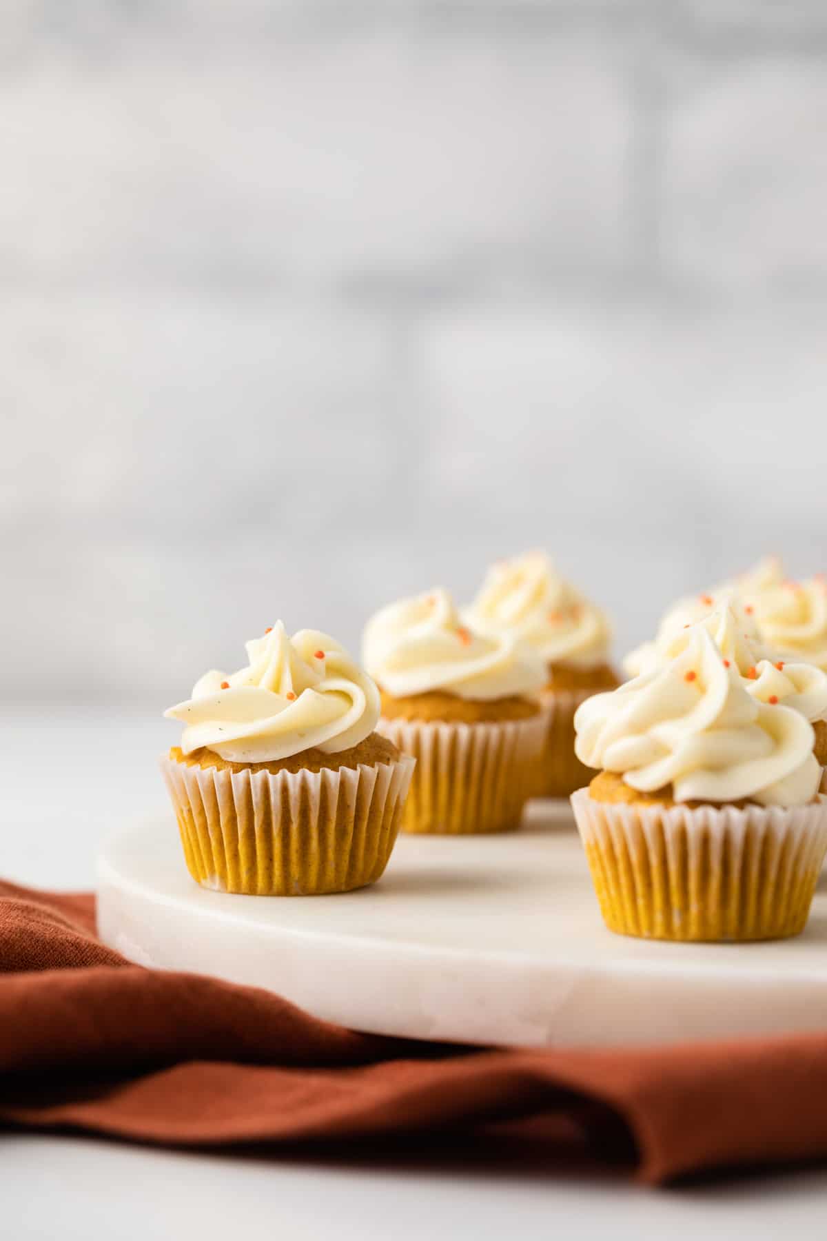 Pumpkin ginger cupcakes on a white serving tray
