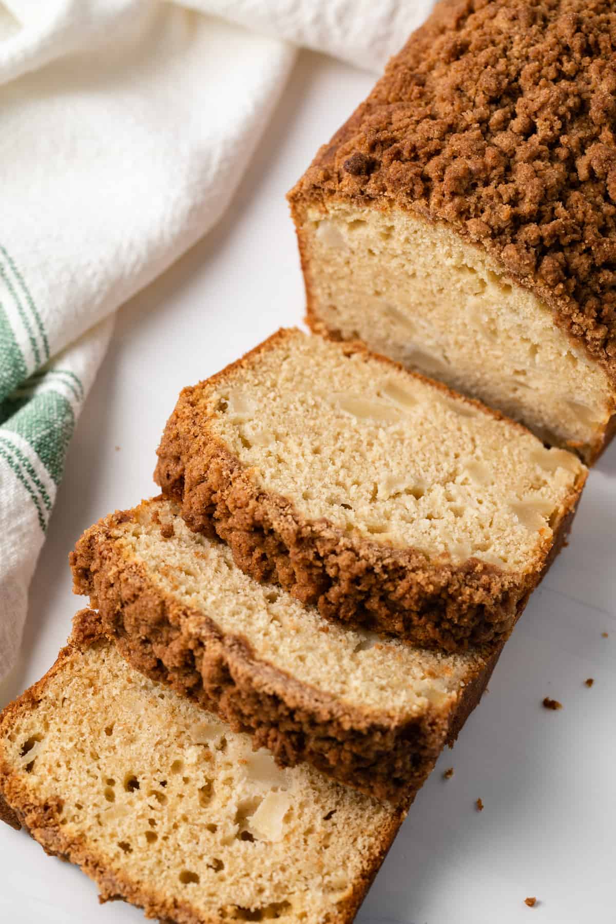 A loaf of spiced pear bread with half of it sliced