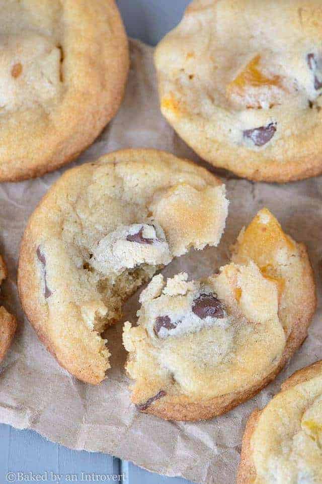 angled view of a chocolate chunk apricot cookie broken into two pieces