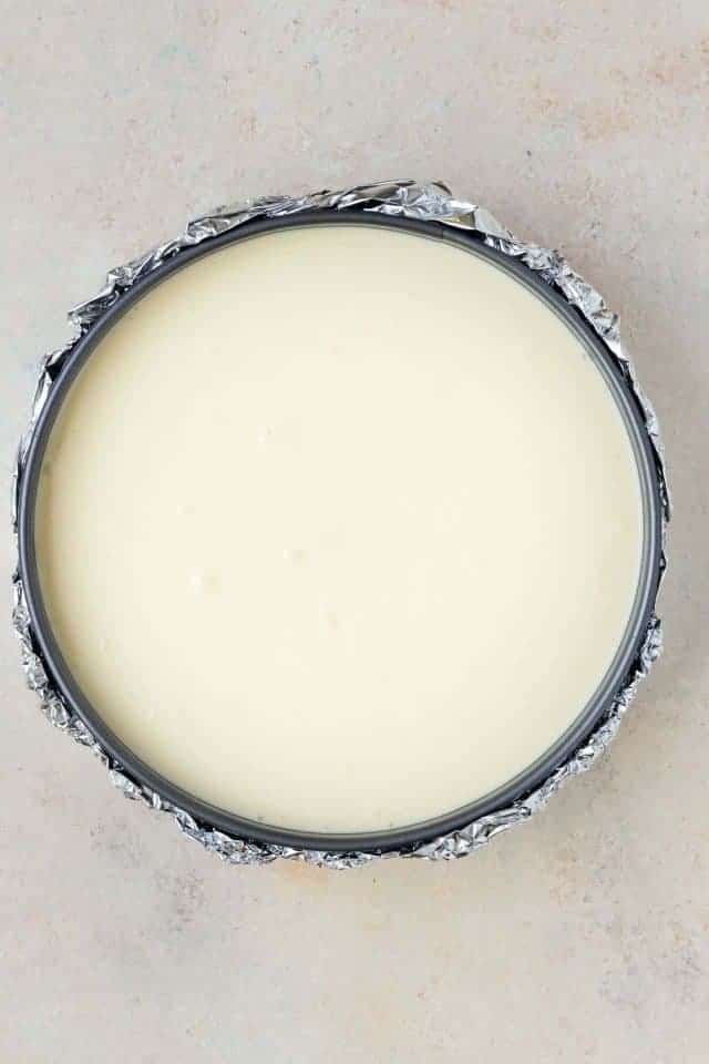 Eggnog cheesecake batter in a pan.