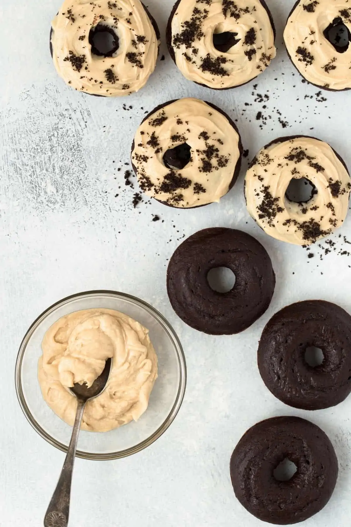 Baked Chocolate Donuts topped rich, creamy Peanut Butter Frosting and a bowl of frosting off to the side.