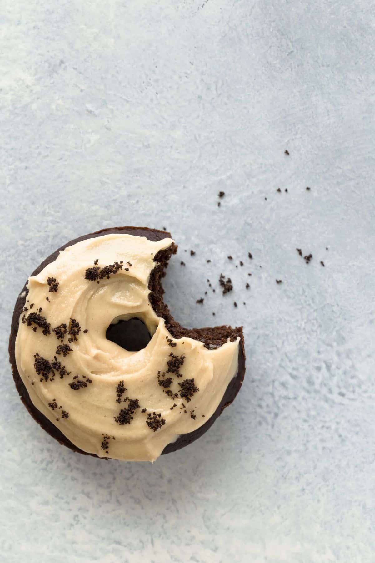 A baked chocolate peanut butter donut with a bite taken out.