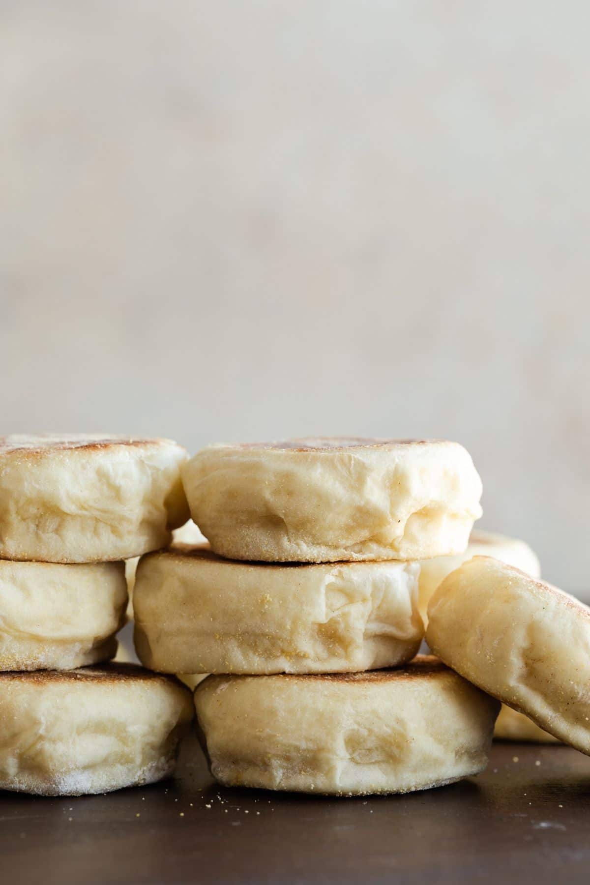 English muffins stacked on brown background