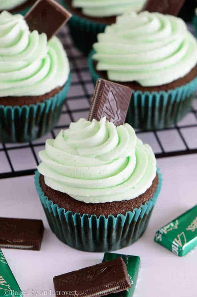 Andes Mint Cupcake on a white background with Andes mint candy scattered around.