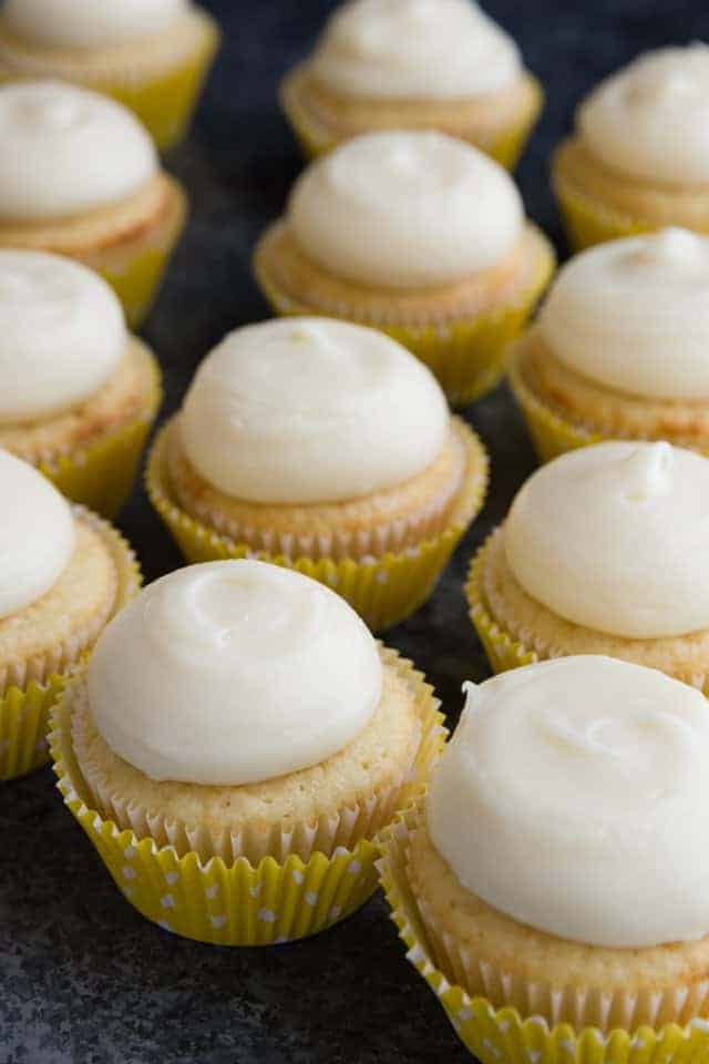 Angled view of vanilla cupcakes with lemon cream cheese frosting.
