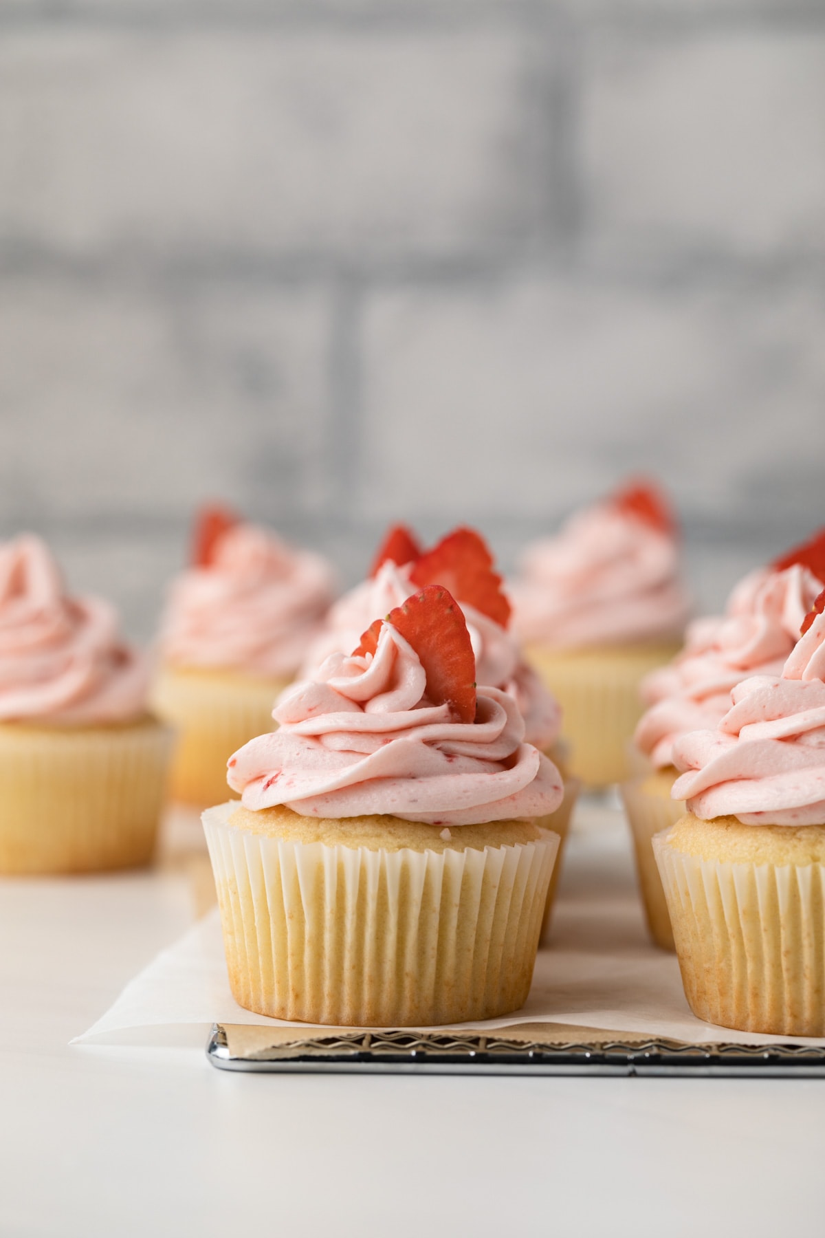 Vanilla yogurt cupcakes on wire rack.