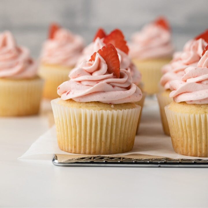 Vanilla yogurt cupcakes on wire rack.