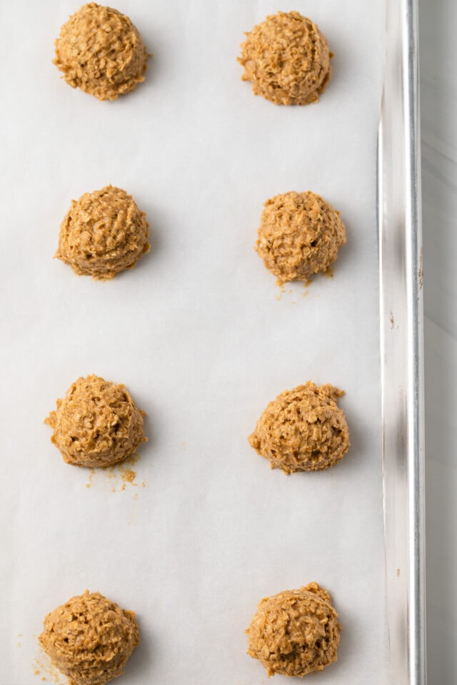 Oatmeal cookie dough balls on baking sheet.
