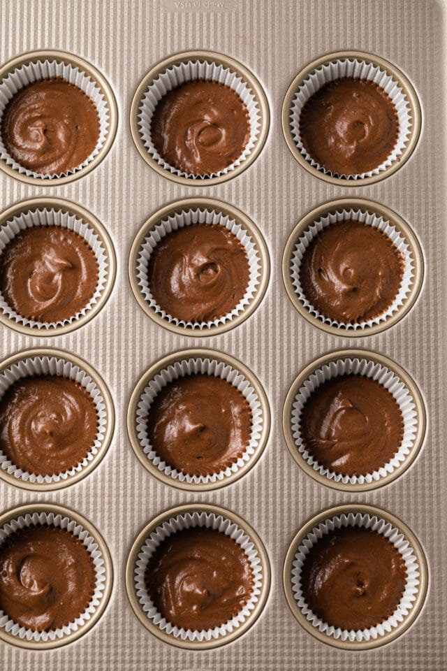 Chocolate cupcake batter in muffin pan.