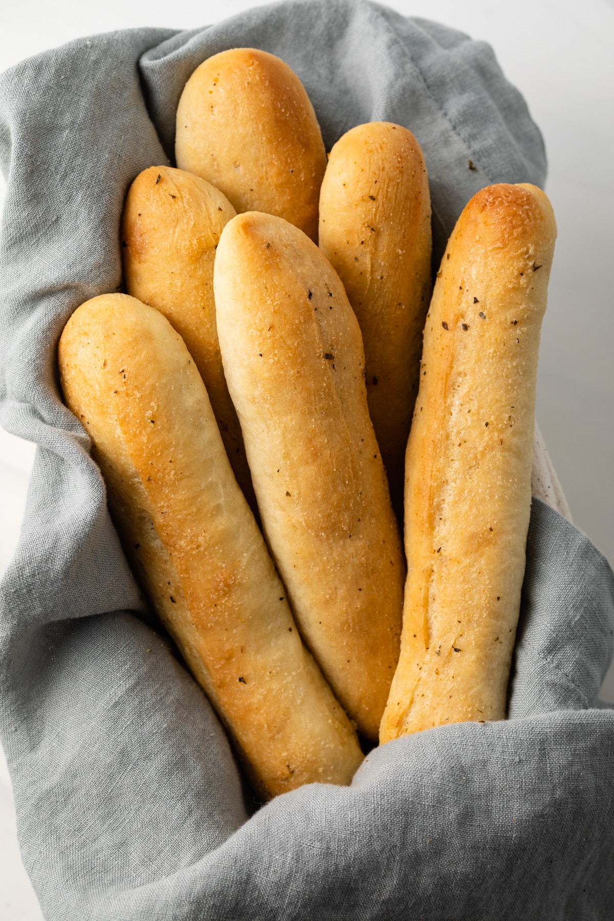 Garlic breadsticks in a bread basket.