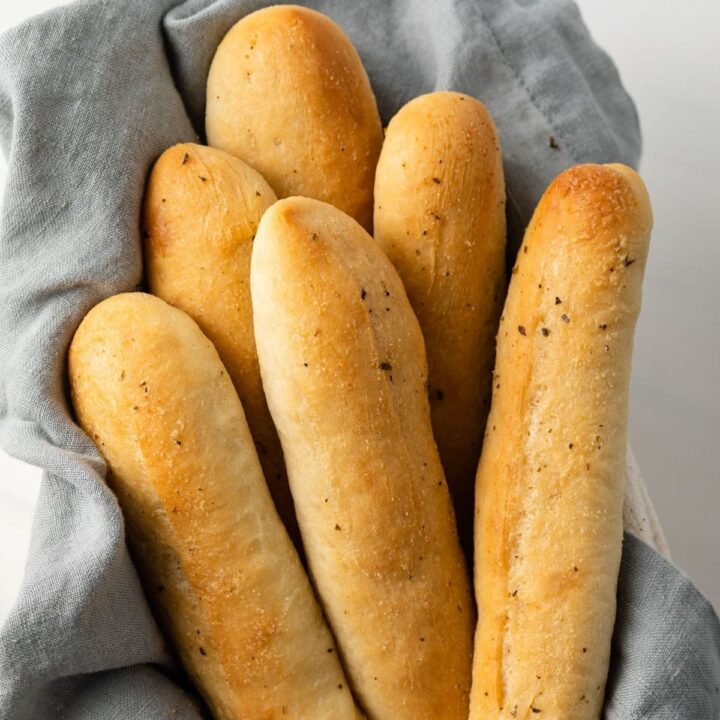 Garlic breadsticks in a bread basket.
