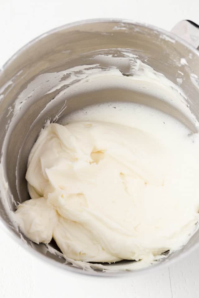 Whipped coconut buttercream frosting in a stainless steel bowl.