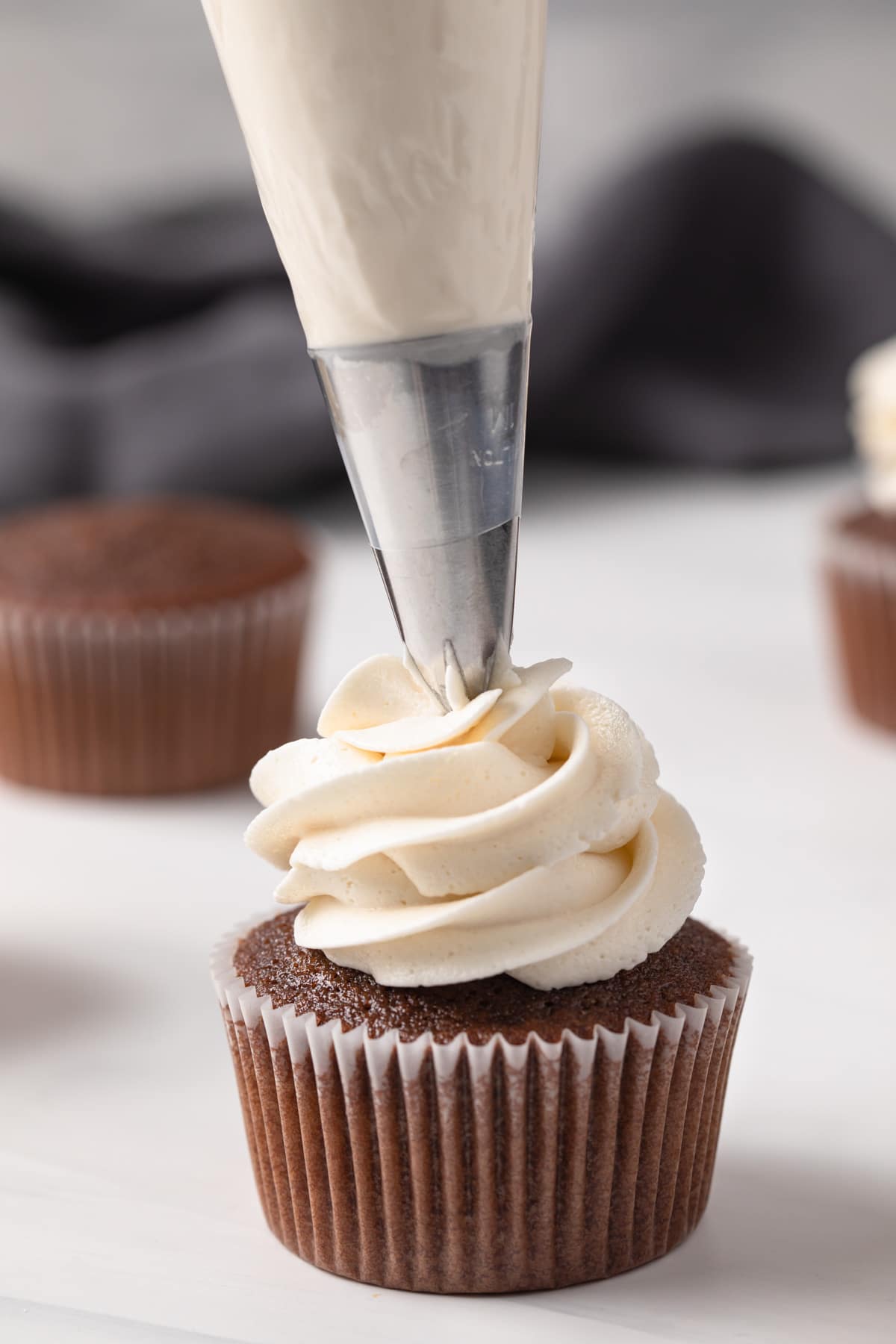 Frosting piped on Dr Pepper cupcakes