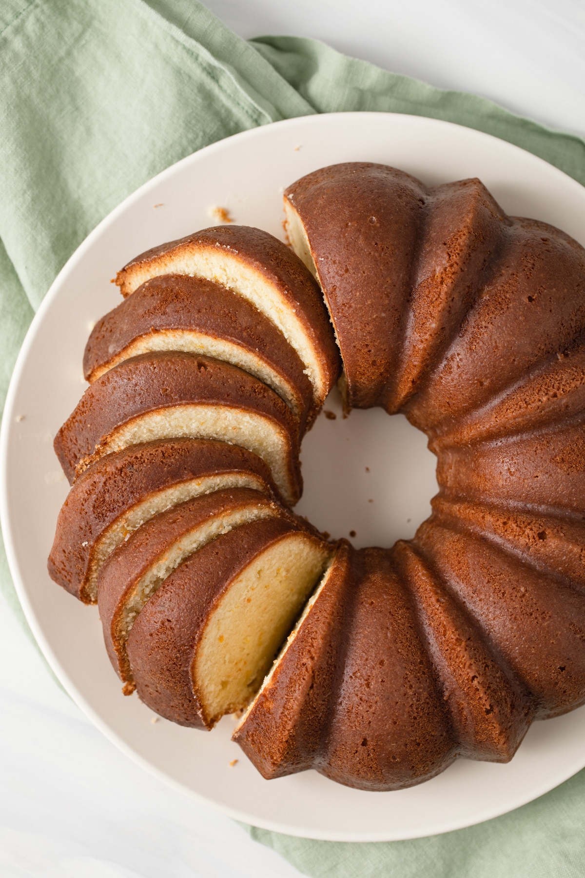 orange pound cake with slices spread on a round plate