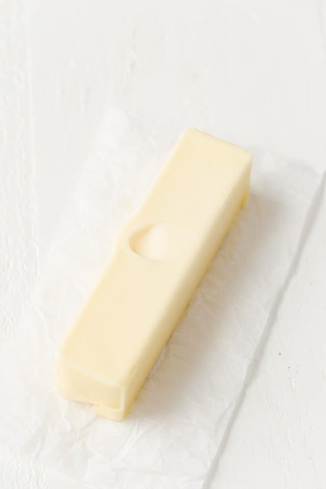 A stick of butter with a finger print in the top to show how soft it is.