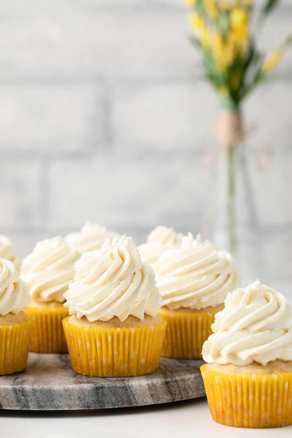 Pineapple cupcakes on a marble round.