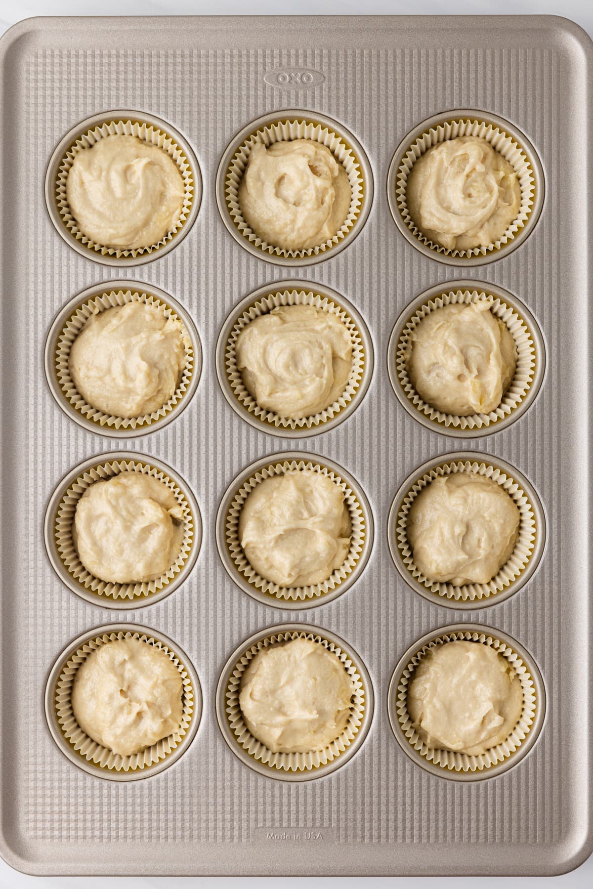 Pineapple cupcake batter in a muffin pan.