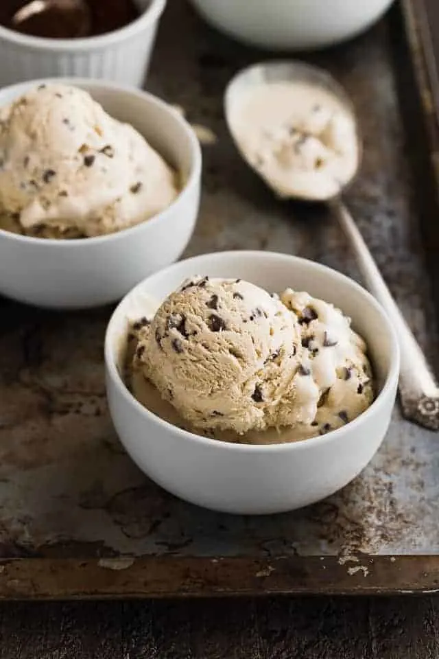 Angled view of two bowls of coffee crunch ice cream on an old baking sheet.